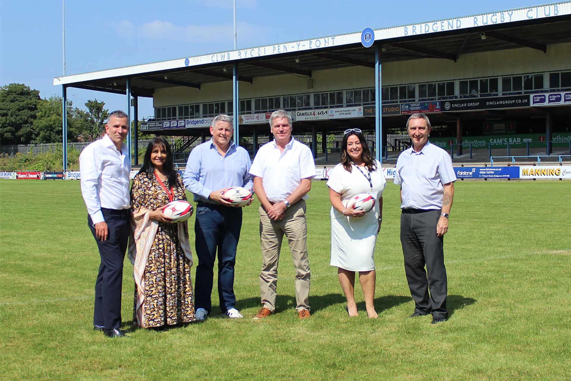 Chief Executive Jake Morgan, Councillor Neelo Farr, Bridgend Ravens Club Secretary Tony Williams, Ospreys Chief Executive Lance Bradley, Communities Director Janine Nightingale and Council Leader John Spanswick celebrate the Ospreys’ return to Dunraven Brewery Field in Bridgend town centre.