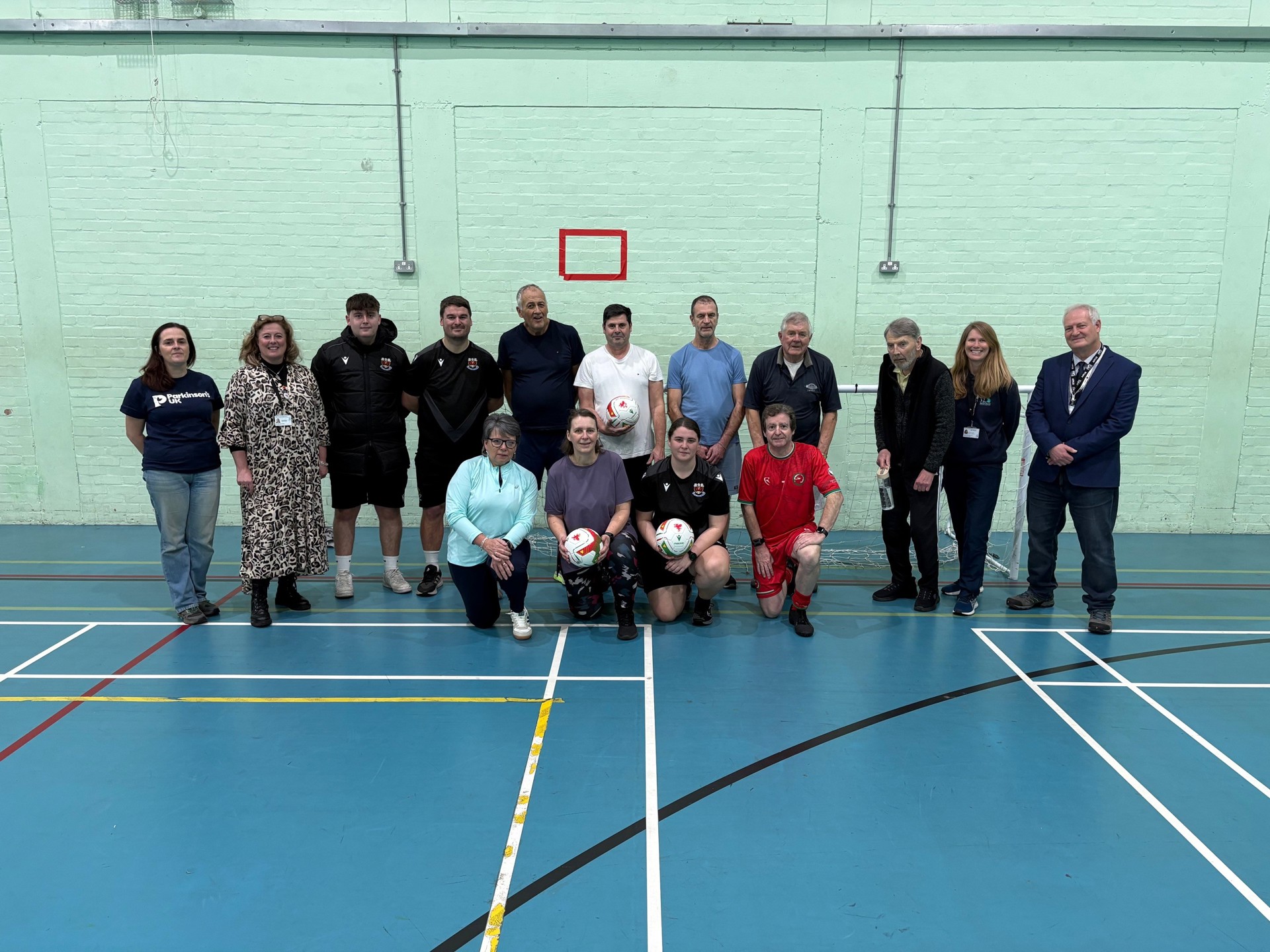 Cllr Melanie Evans and Cllr Gary Haines pictured with the players and representatives from the Parkinson’s charity along with members of Penybont Football Club.