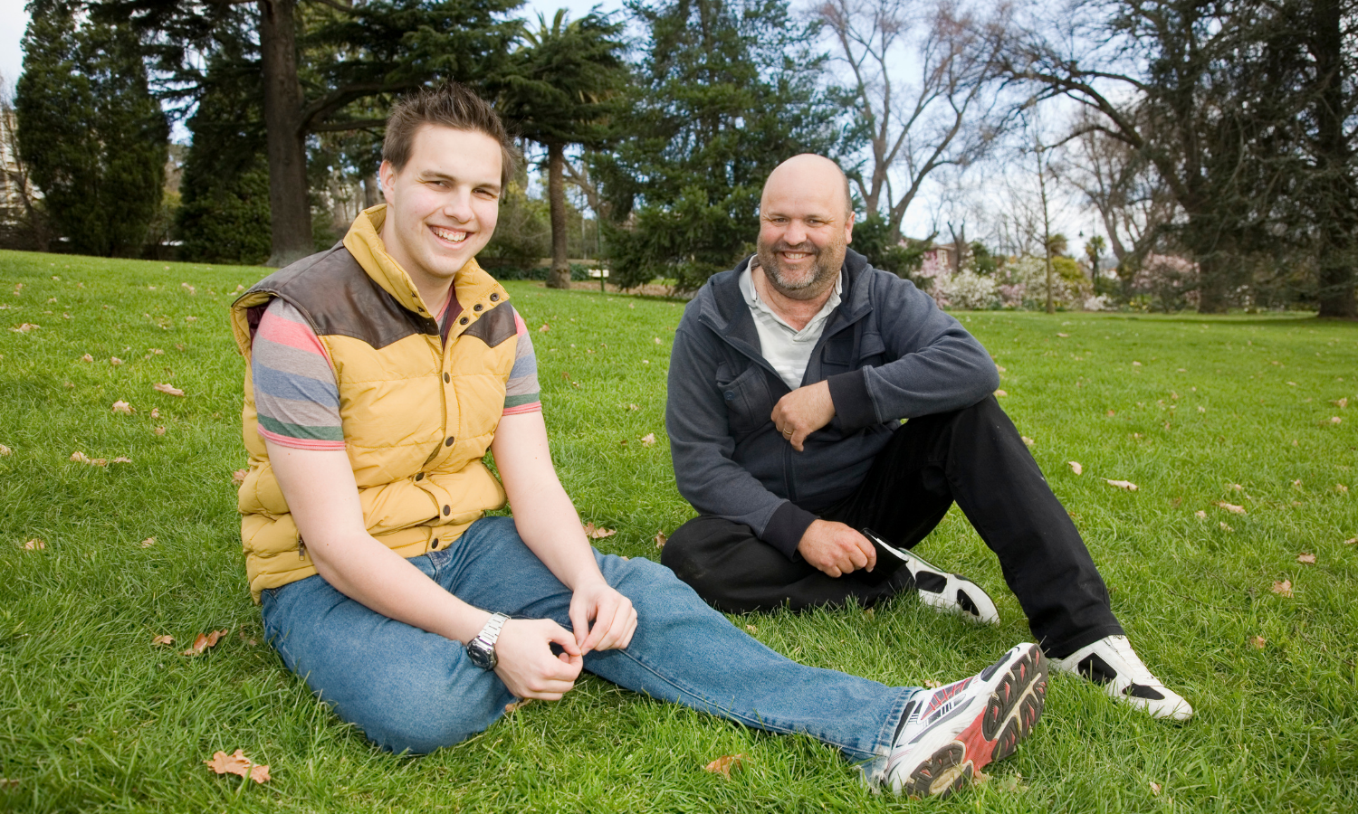 Two men sitting on the grass